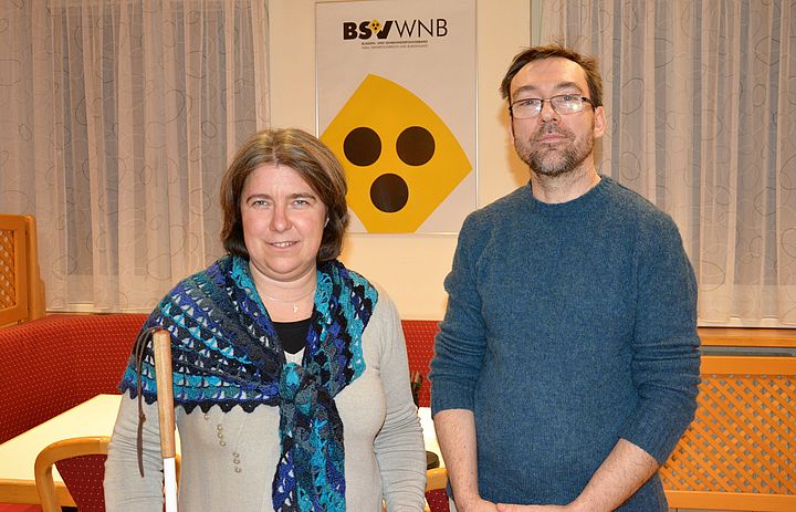 Marion Putzer-Schimack und Alexander Guano stehen vor dem BSVWNB-Logo in den Louis Braille Stuben