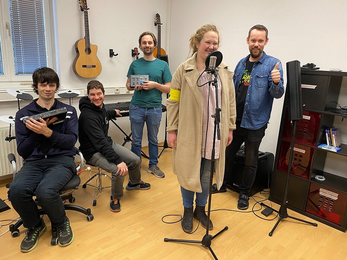 Drei jugendliche VJA-Teilnehmer:innen sowie zwei VJA-Betreuer posieren mit dem neuen Musikequipment für ein Gruppenfoto.