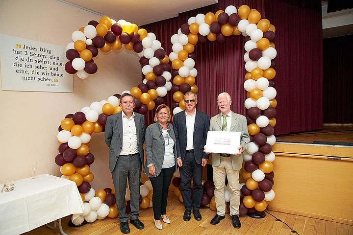 Vor einem knapp 3 Meter hohen, aus Ballons gefertigten „20“er vor der Bühne werden die Ehrengäste fotografiert.