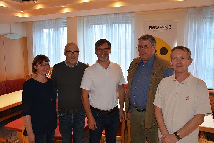 Eine Expertin und vier Experten für POPTIS stehen für die Kamera nebeneinander vor dem Podiumstisch in den Louis Braille Stuben