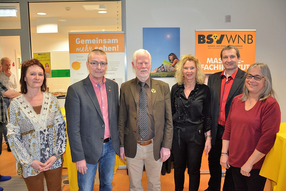 Sechs Personen stehen vor Roll-Ups der Massage und der Beruflichen Assistenz im Vorraum der Außenstelle St. Pölten und lächeln in die Kamera