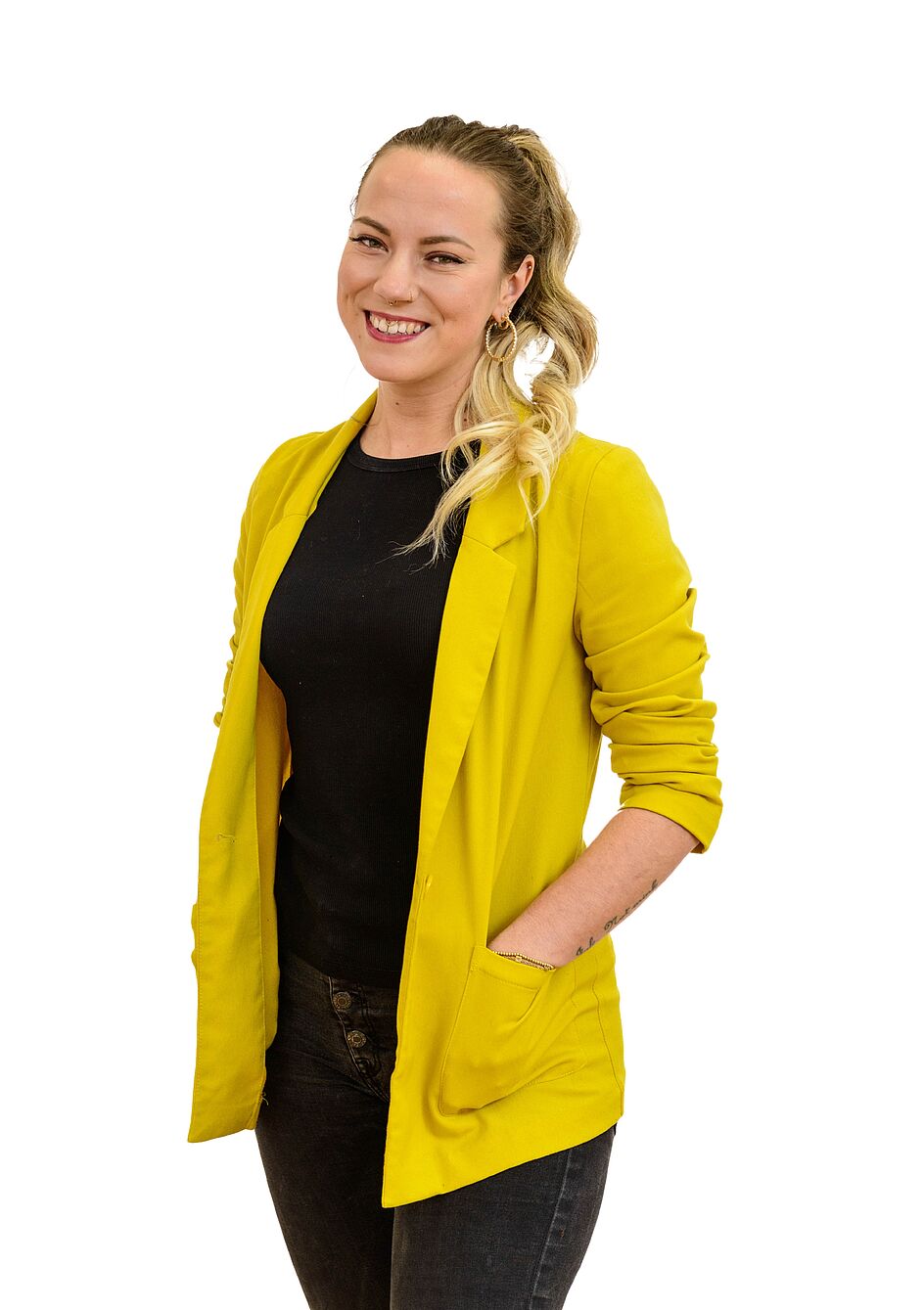 Das Bild zeigt eine lächelnde Frau in einem gelben Blazer mit blondem Haar vor weißem Hintergrund.