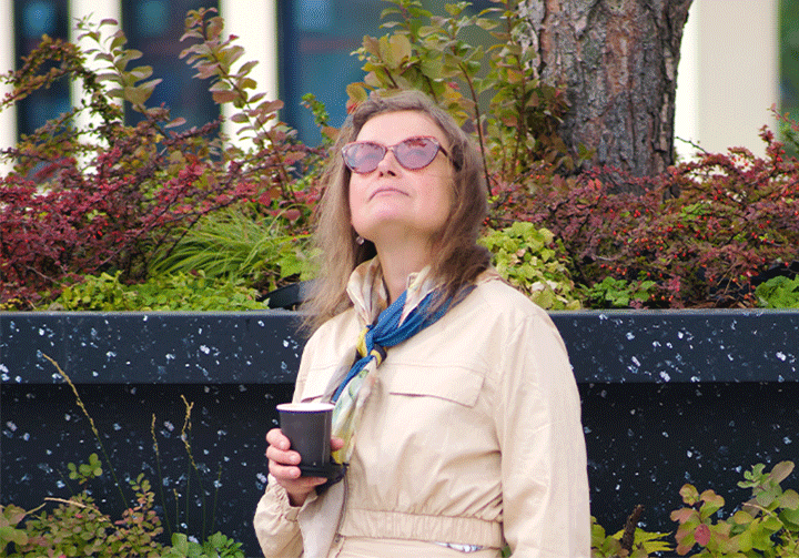 Eine Frau im mittleren Alter schaut sehnsüchtig in die Ferne